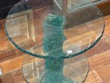 une table en verre avec un plateau en verre posée sur un parquet