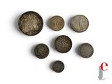 several old coins are arranged in a row on a white surface