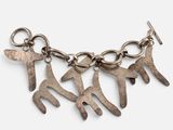 un gros plan sur un bracelet en métal orné de cinq breloques