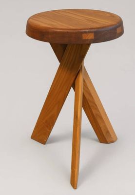un gros plan sur une petite table en bois aux deux pieds croisés