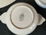 a close up of a white bowl with a crest on it