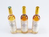 three bottles of wine sitting next to each other on a white surface