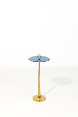 une table d'appoint dorée et bleue avec un plateau en verre