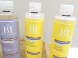 three bottles of shampooe sitting on a cutting board