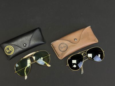 trois paires de lunettes de soleil et un étui posés sur une surface noire