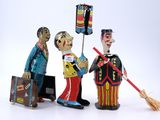 three figurines of men with luggage and a broom