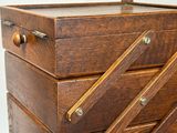 a small wooden box with three drawers on it