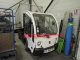 un petit camion blanc garé à l'intérieur d'un bâtiment