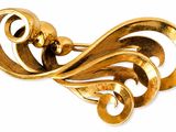 an image of a gold brooch with swirls on a white background