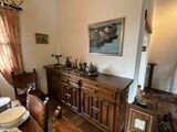 a dining room with a table, chairs, and a painting on the wall
