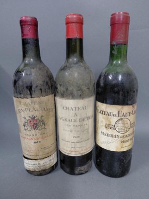 trois bouteilles de vin sont alignées sur une surface grise