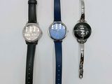 four different watches are lined up on a white surface