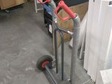 un diable avec une poignée rouge dans un garage
