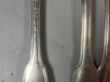 three forks and two spoons that are on a table