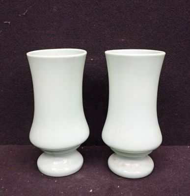deux vases blancs posés l'un à côté de l'autre sur une table
