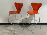 une paire de chaises orange posées contre un mur blanc dans une pièce