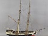 une petite maquette de bateau posée sur un socle en bois