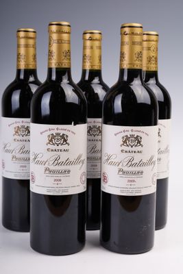 quatre bouteilles de vin sont alignées sur une surface blanche