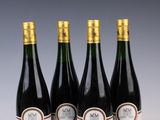quatre bouteilles de vin sont alignées sur une table