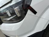 a close up of the front of a white truck with a sticker on it