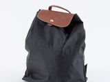 un sac à dos noir avec une poignée marron sur fond blanc