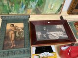 many pictures and paintings on the floor next to a purse