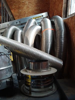a pile of metal pipes and a blower in a room