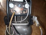 an air compressor sitting on the floor with a hose attached