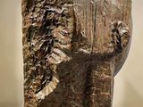 sculpture of a man ' s head on a pedestal in a museum