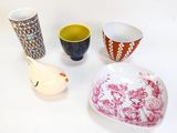 quatre bols et tasses différents posés sur une surface blanche