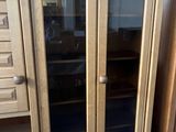 a cabinet with glass doors and drawers in a room