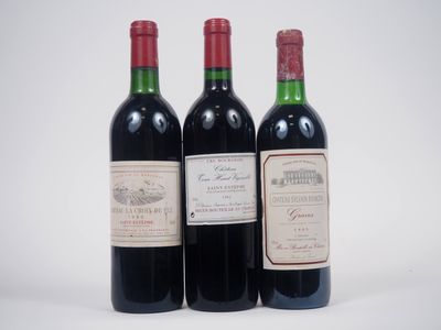 trois bouteilles de vin rouge posées l'une à côté de l'autre sur une surface blanche