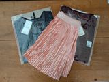 two skirts and a shirt on a wooden floor
