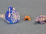 un oiseau bleu posé à côté de deux petites figurines sur une table