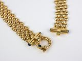 a close up of a gold chain bracelet with a clasp