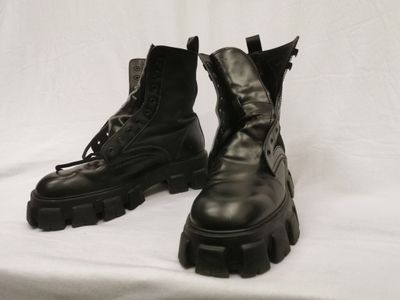 une paire de bottes militaires noires à lacets sur fond blanc