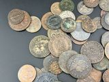 a pile of old coins on a black surface