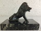 statue of a dog sitting on a marble base on a white surface