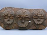 a close up of a stone object with three faces on it