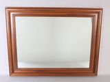 an image of a mirror on a white wall with a wooden frame