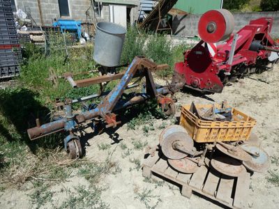 a small tractor with a plow attached to it in the dirt
