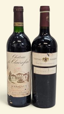 deux bouteilles de vin posées l'une à côté de l'autre sur une surface blanche