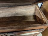 a wooden chest with a lid open on the floor
