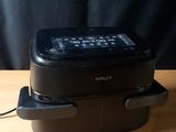 un micro-ondes noir posé sur une table en bois