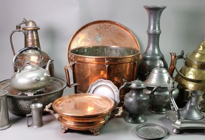 many different types of silver and copper items on the table