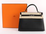 a black and white handbag next to an orange box