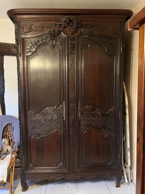 a large wooden armoire in the corner of a room