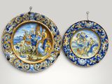 une paire d'assiettes bleues et dorées ornées de motifs, accrochées au mur
