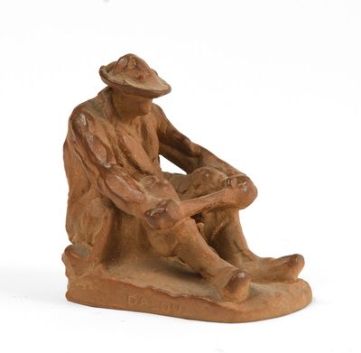 figurine représentant un homme assis sur un rocher, coiffé d'un chapeau