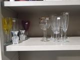 many wine glasses sitting on a shelf in a cabinet